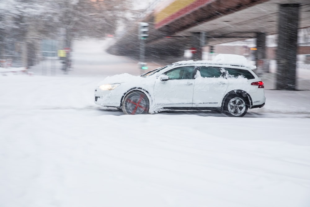 white sedan on snow covered road during daytime