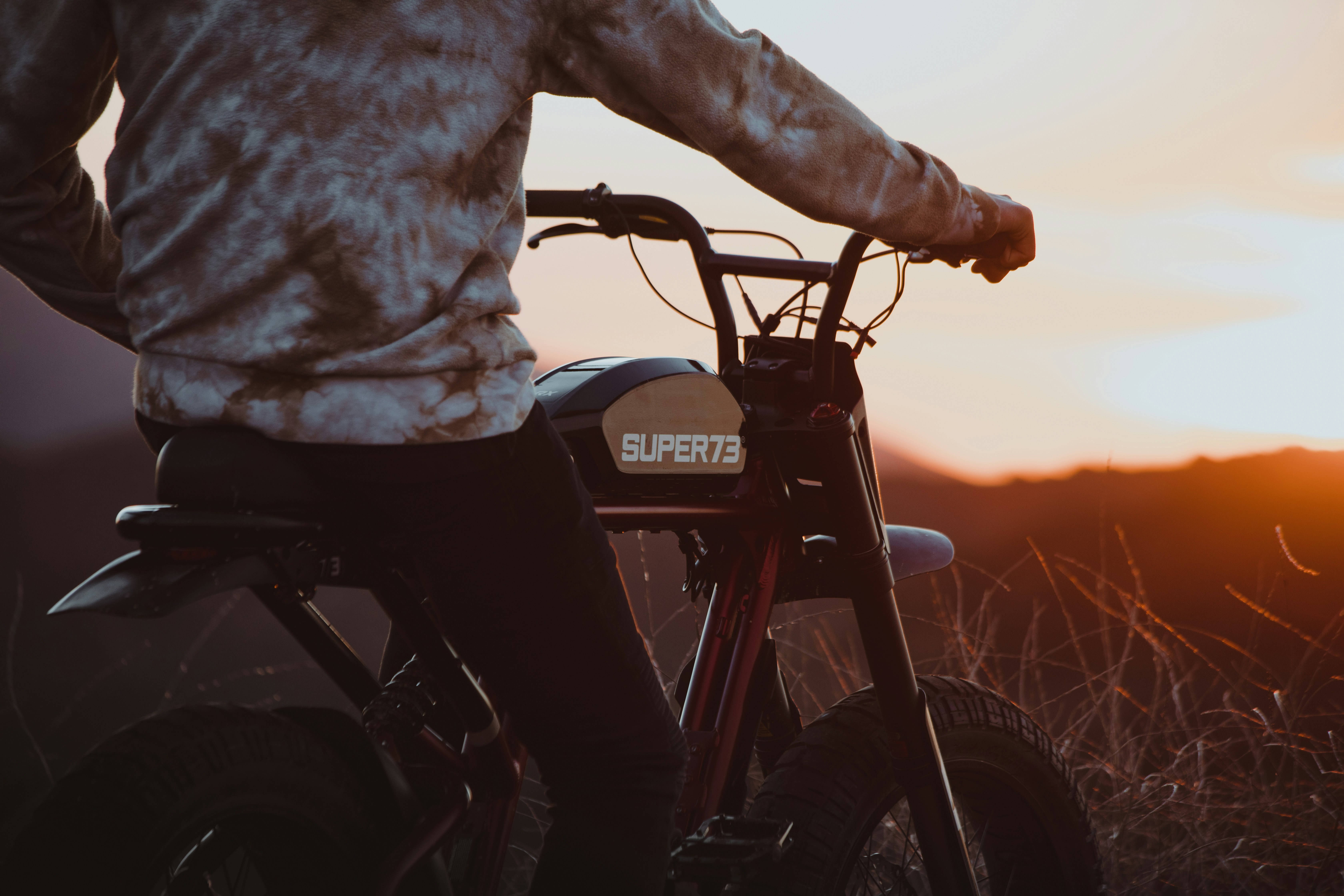 Male model on electric bicycle enjoying sunset