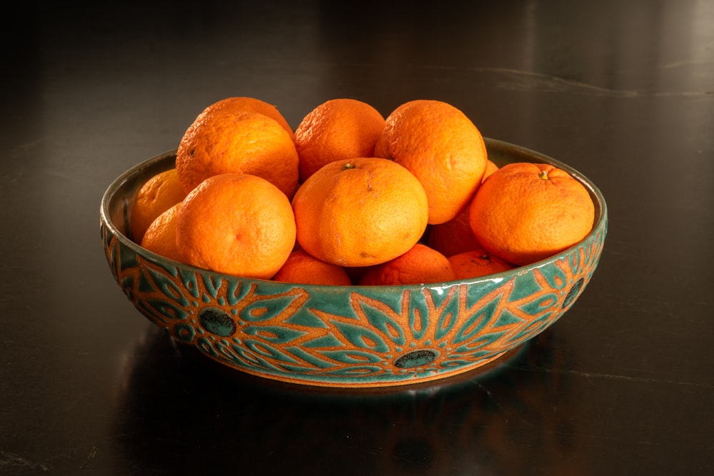 orange fruits on blue and white ceramic bowl