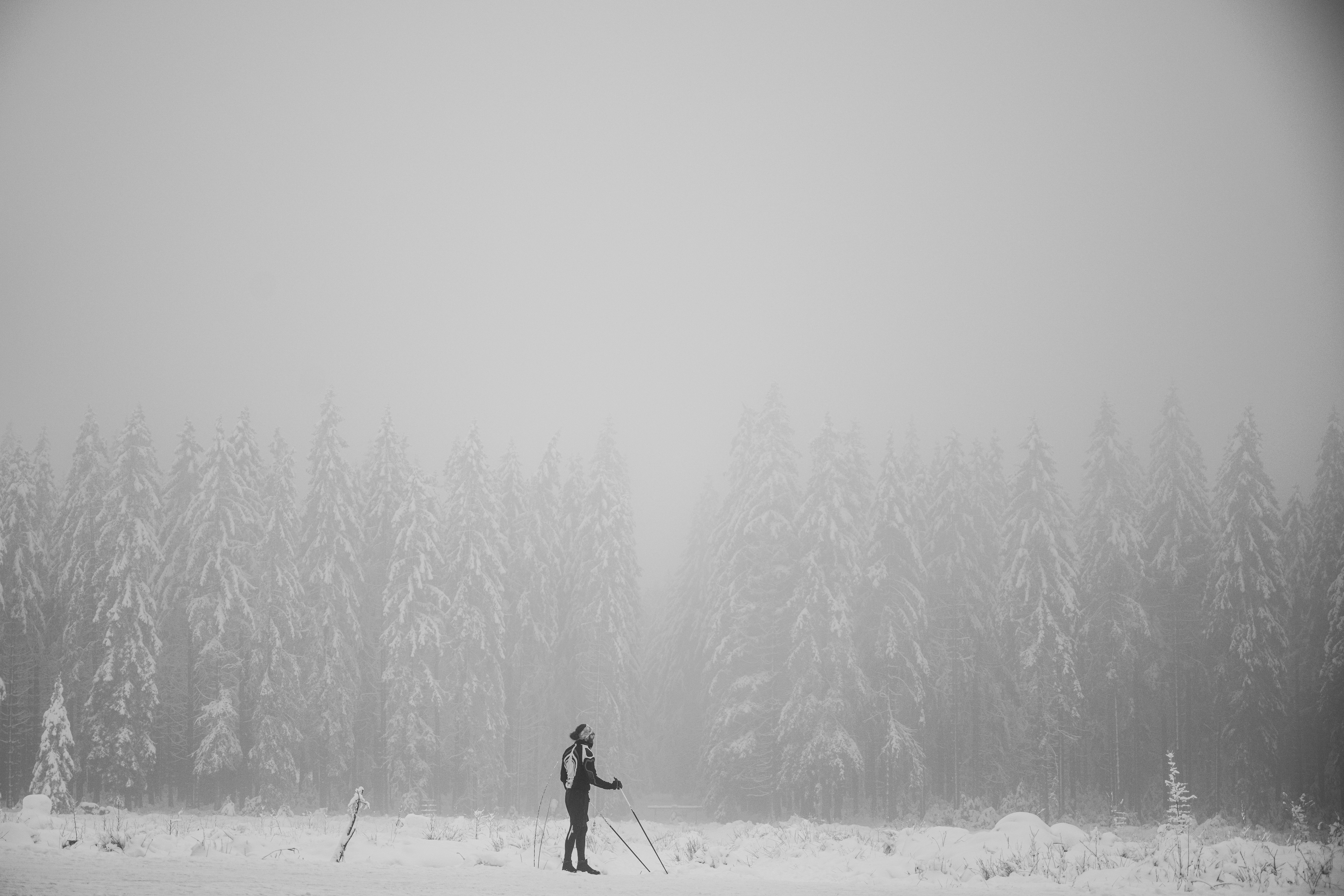 person in black jacket and black pants walking on snow covered ground during daytime