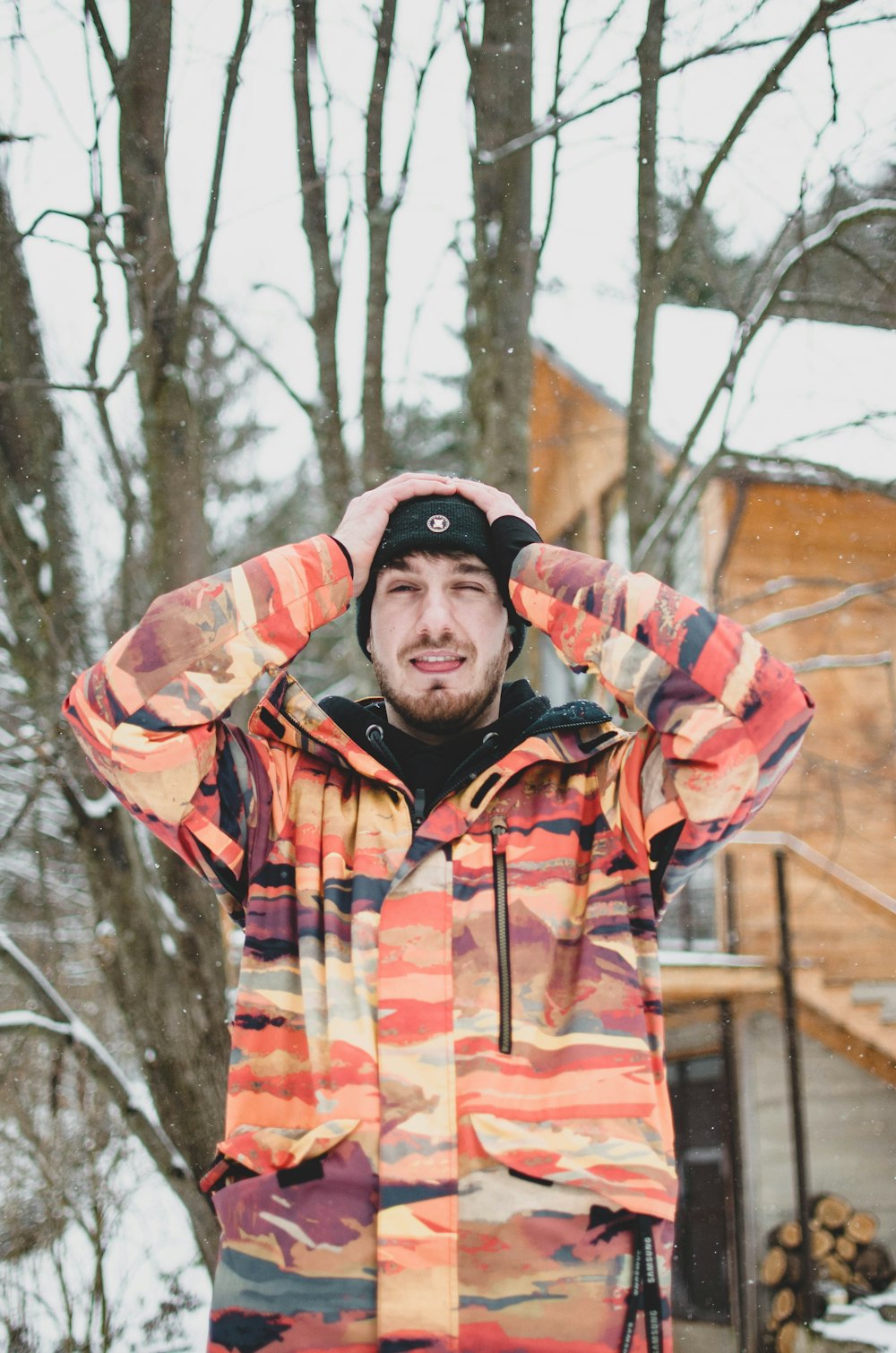 man in red and white plaid jacket standing near trees during daytime