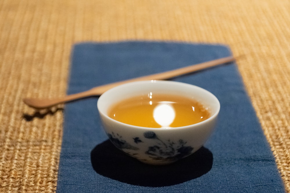 white and black ceramic bowl with brown wooden stick