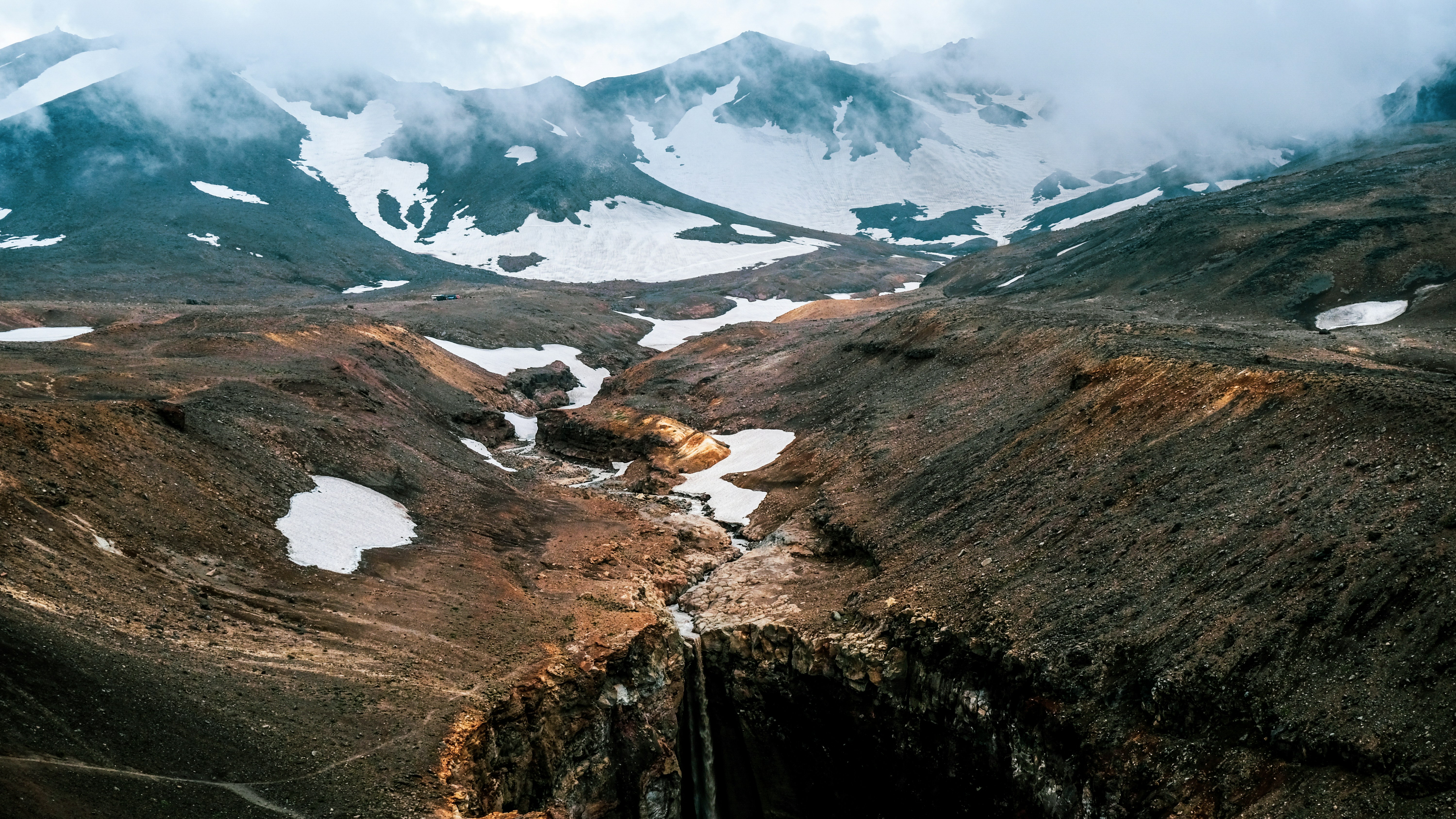 brown and gray mountains under white clouds during daytime