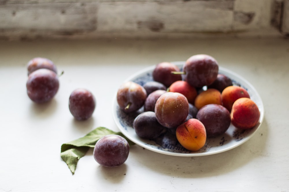 red and purple grapes on white ceramic bowl