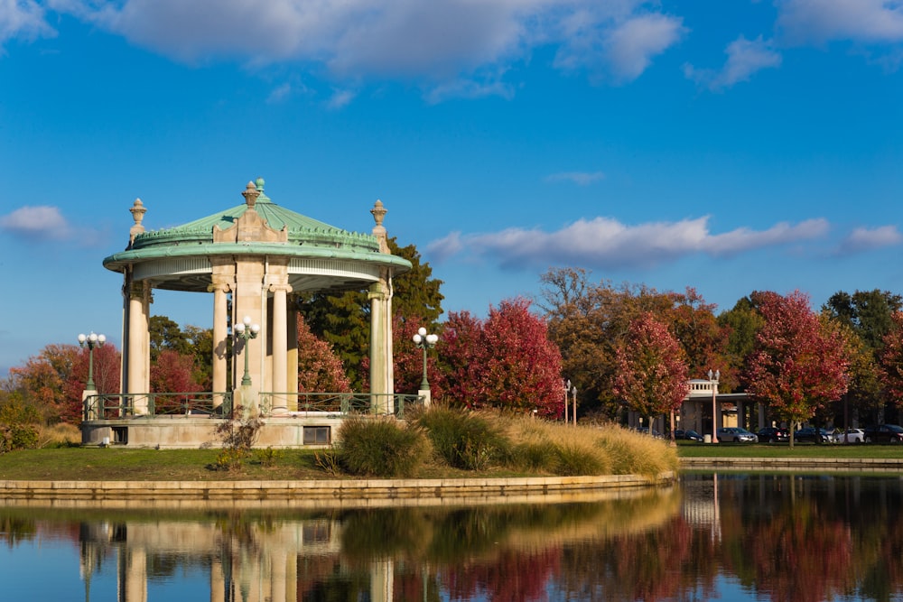 gazebo bianco e verde vicino allo specchio d'acqua durante il giorno