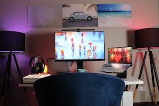 black flat screen tv turned on near black laptop computer