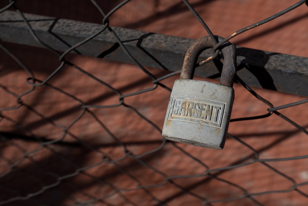 brass padlock on black metal fence