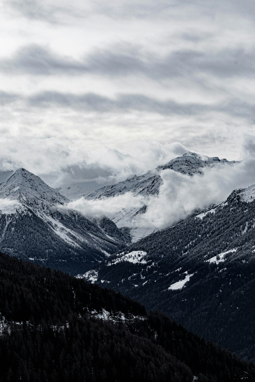 montagne coperte di neve sotto il cielo nuvoloso durante il giorno