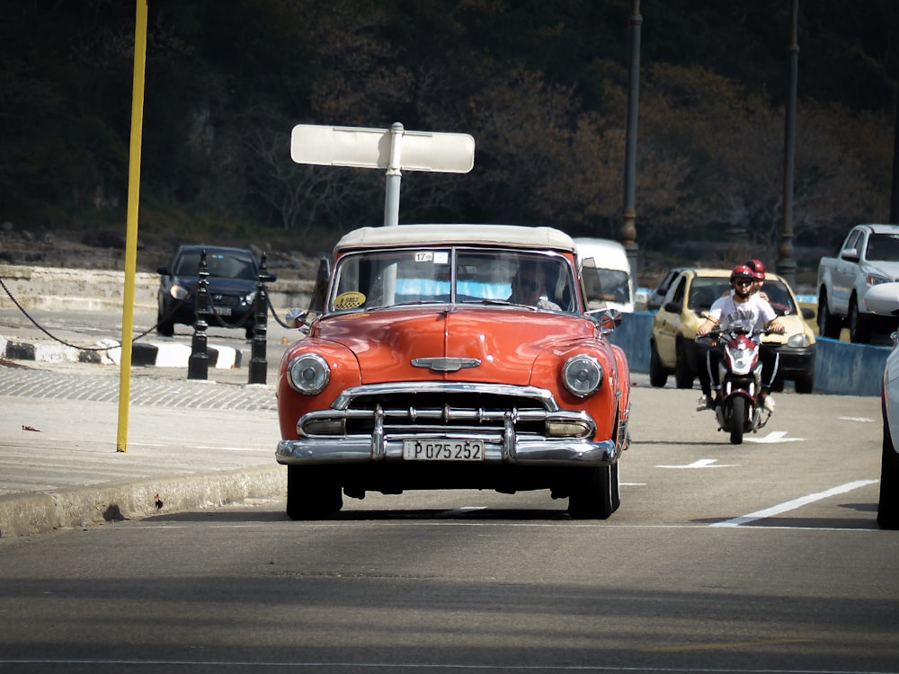 red car on the road during daytime