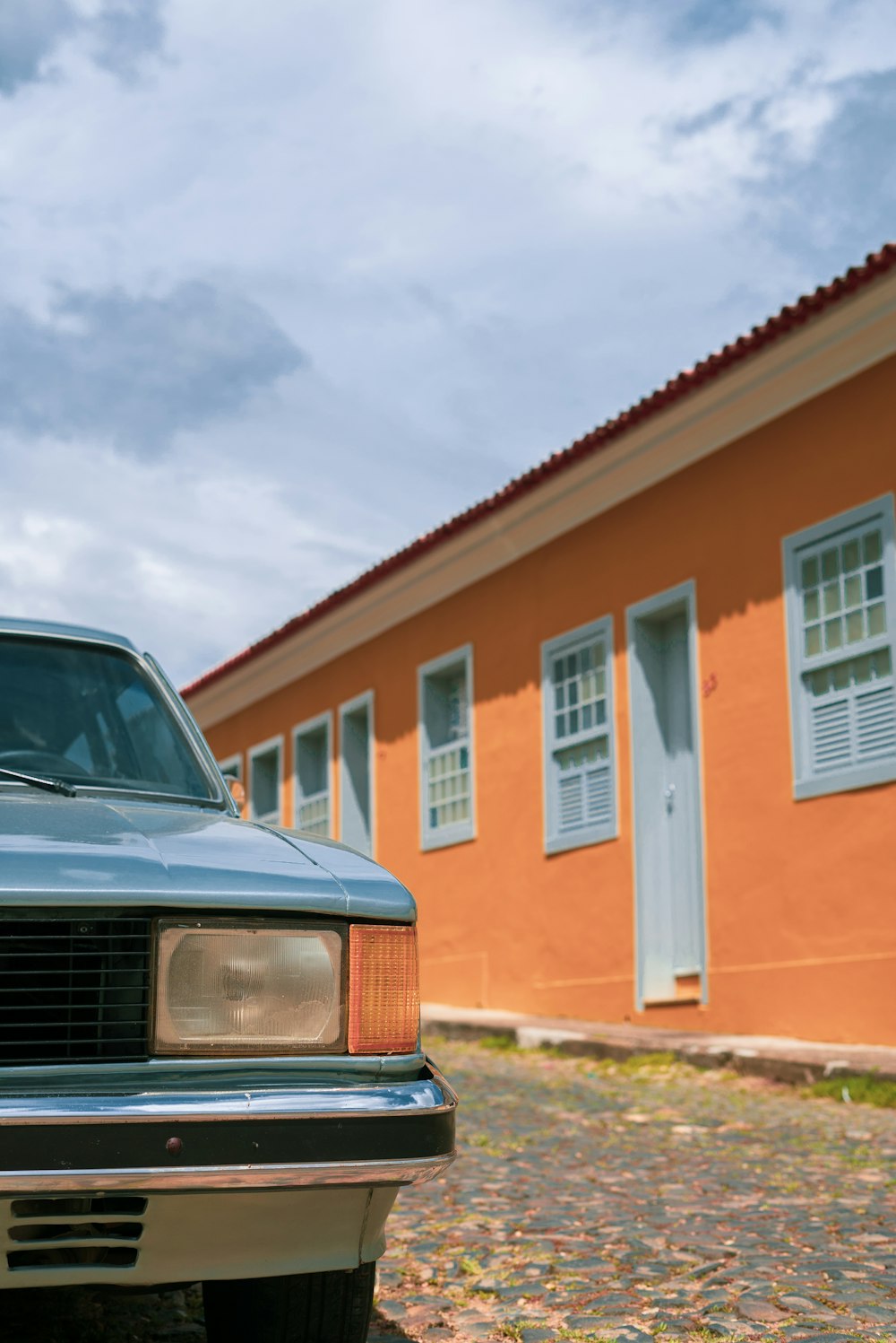 black car parked in front of brown and white concrete building during daytime