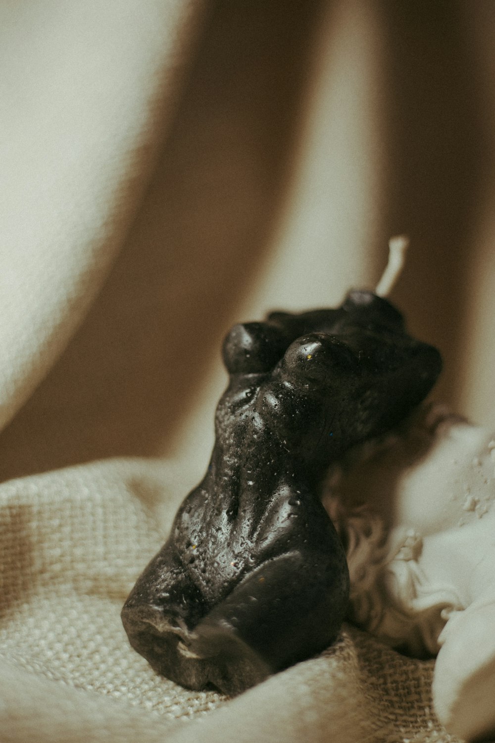black frog figurine on white textile