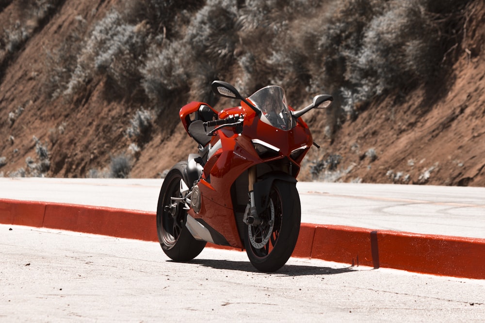 orange and black sports bike on white snow field during daytime