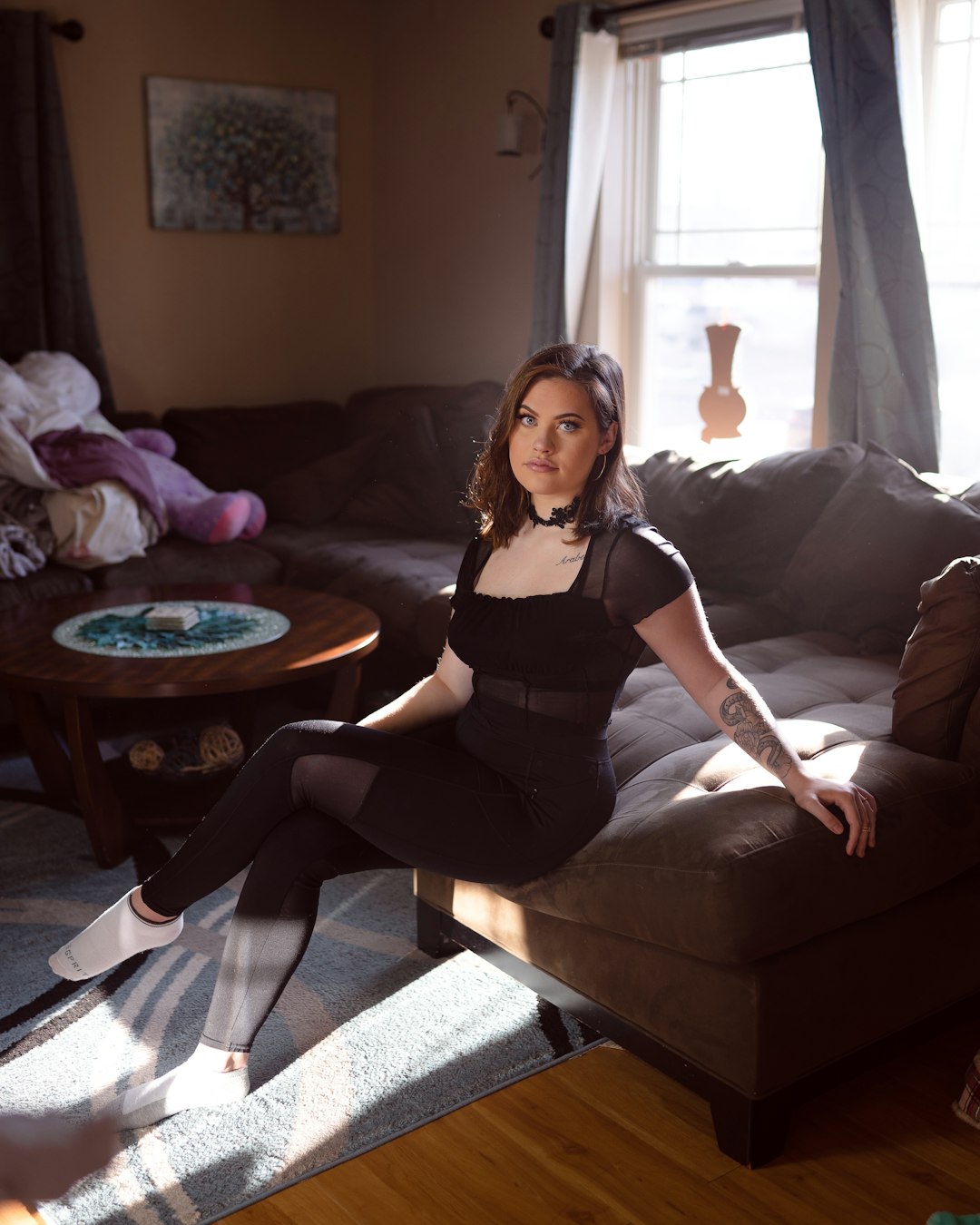 woman in black tank top sitting on brown couch