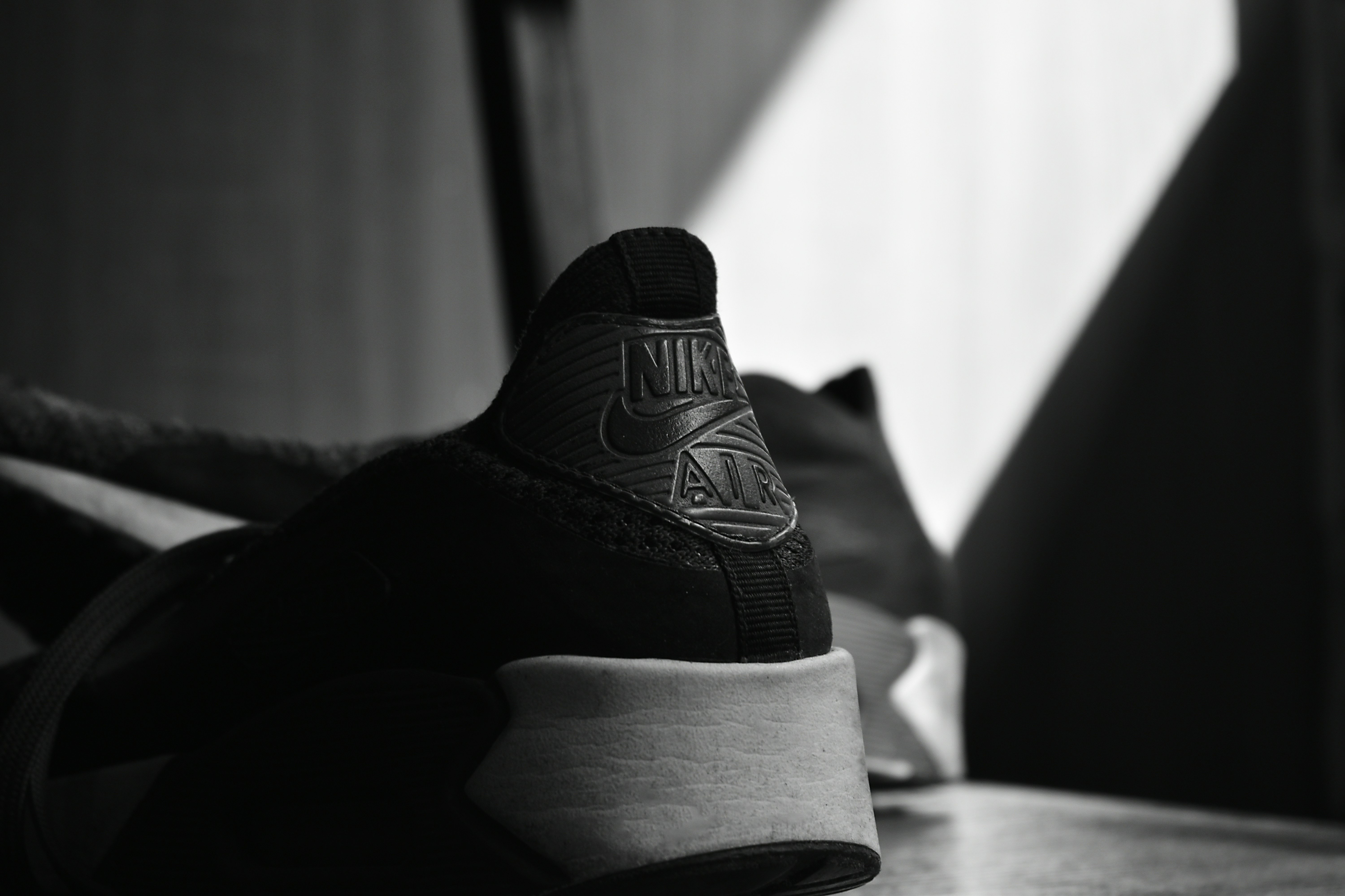 Close-up of Nike swoosh logo on athletic shoe in dramatic low-key lighting