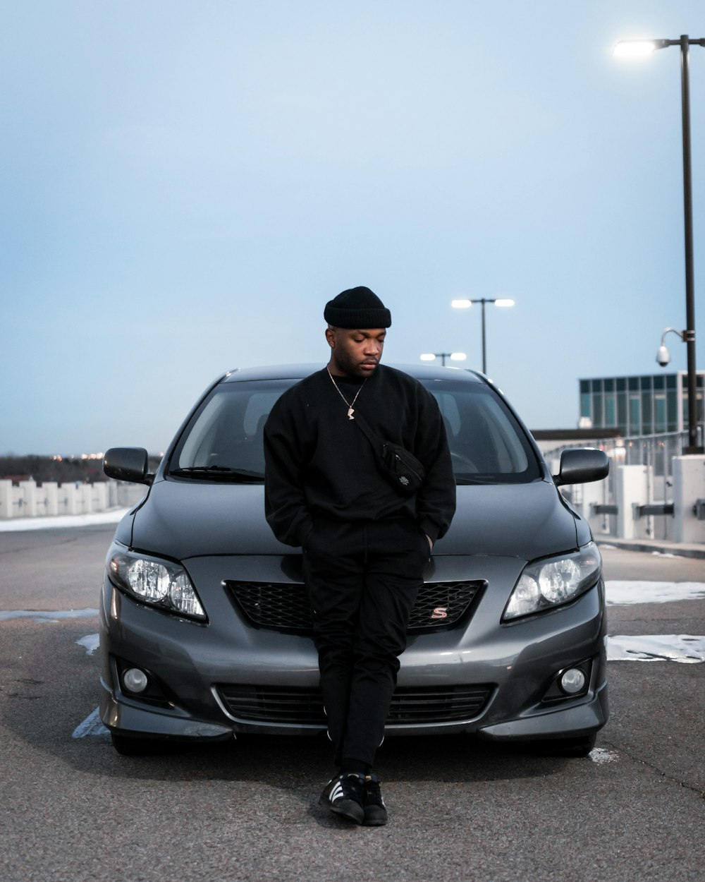 man in black jacket standing beside black honda car during daytime