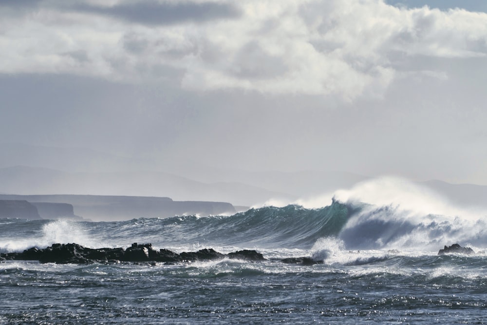 ocean waves under cloudy sky during daytime