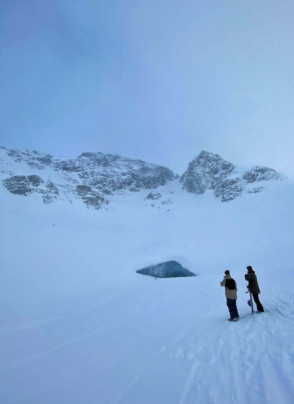 2 person walking on snow covered ground during daytime