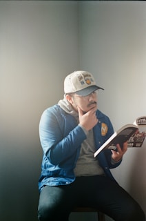 man in gray hoodie and blue pants sitting on gray couch