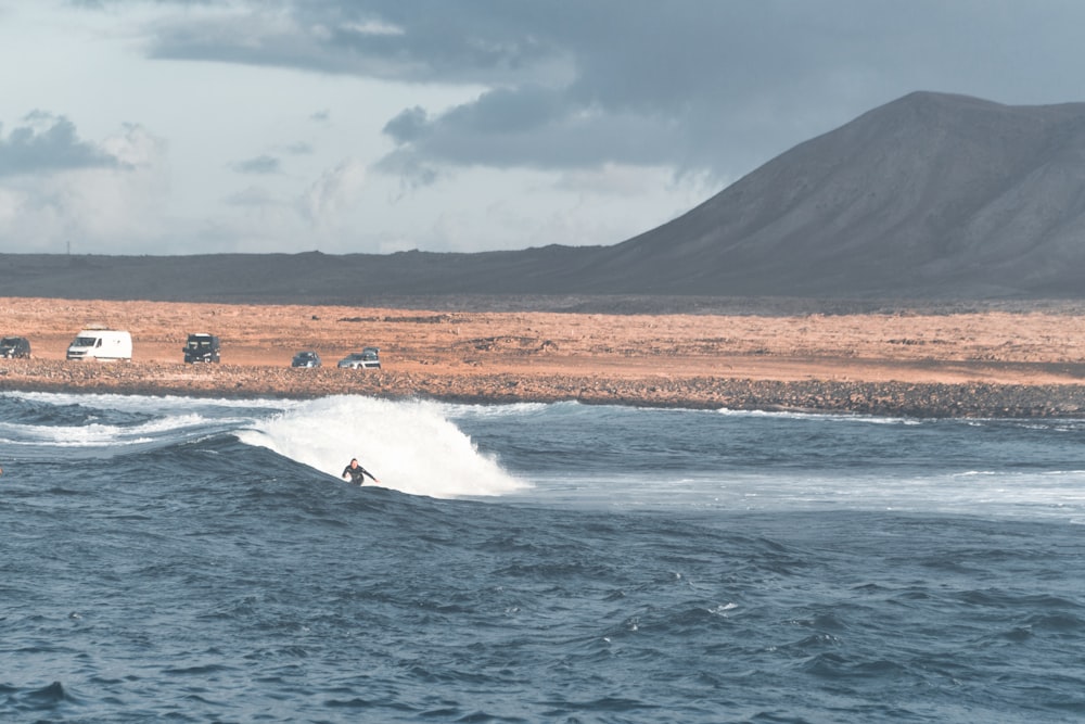 person surfing on sea waves during daytime