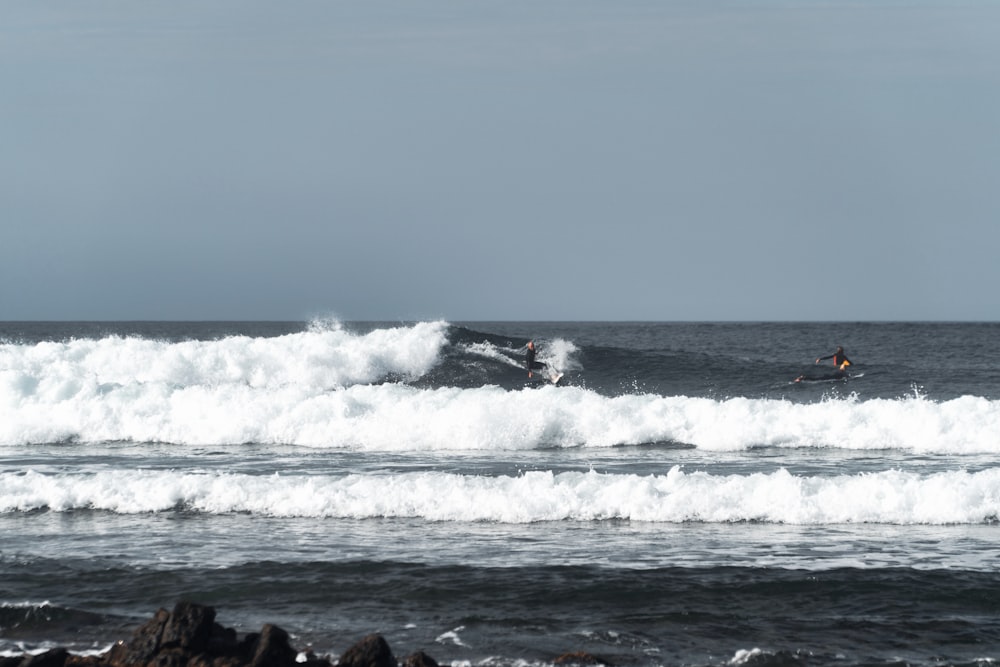 昼間、波の上でサーフィンをする人々