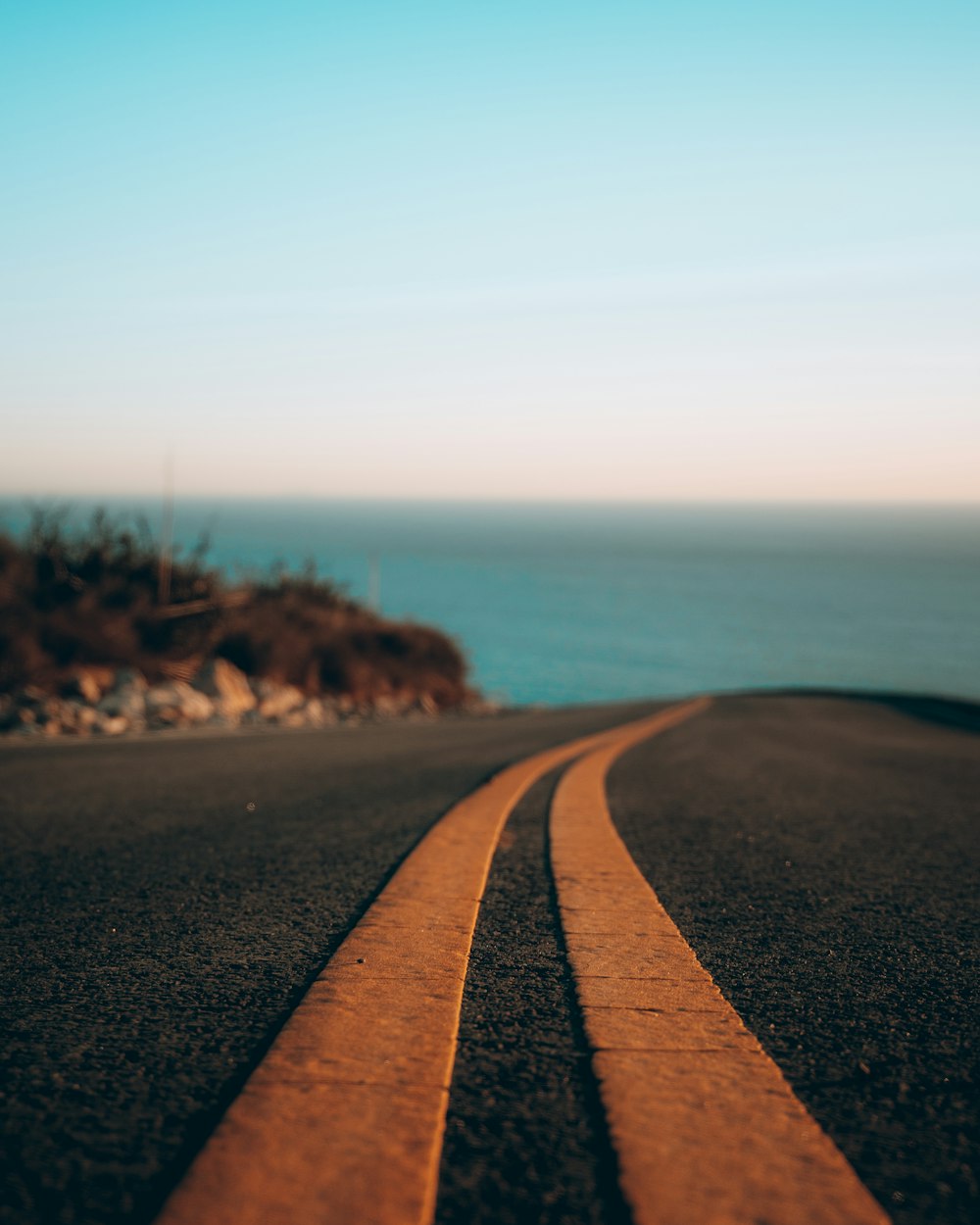 black asphalt road near body of water during daytime