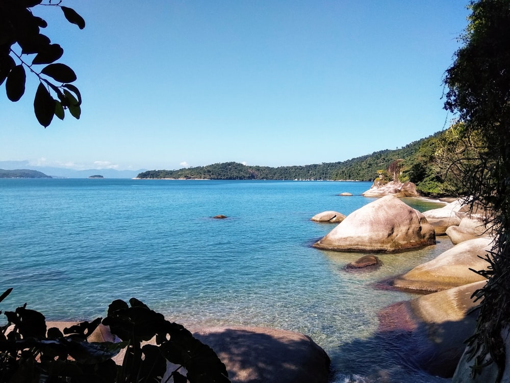 white and gray rock formation on body of water during daytime