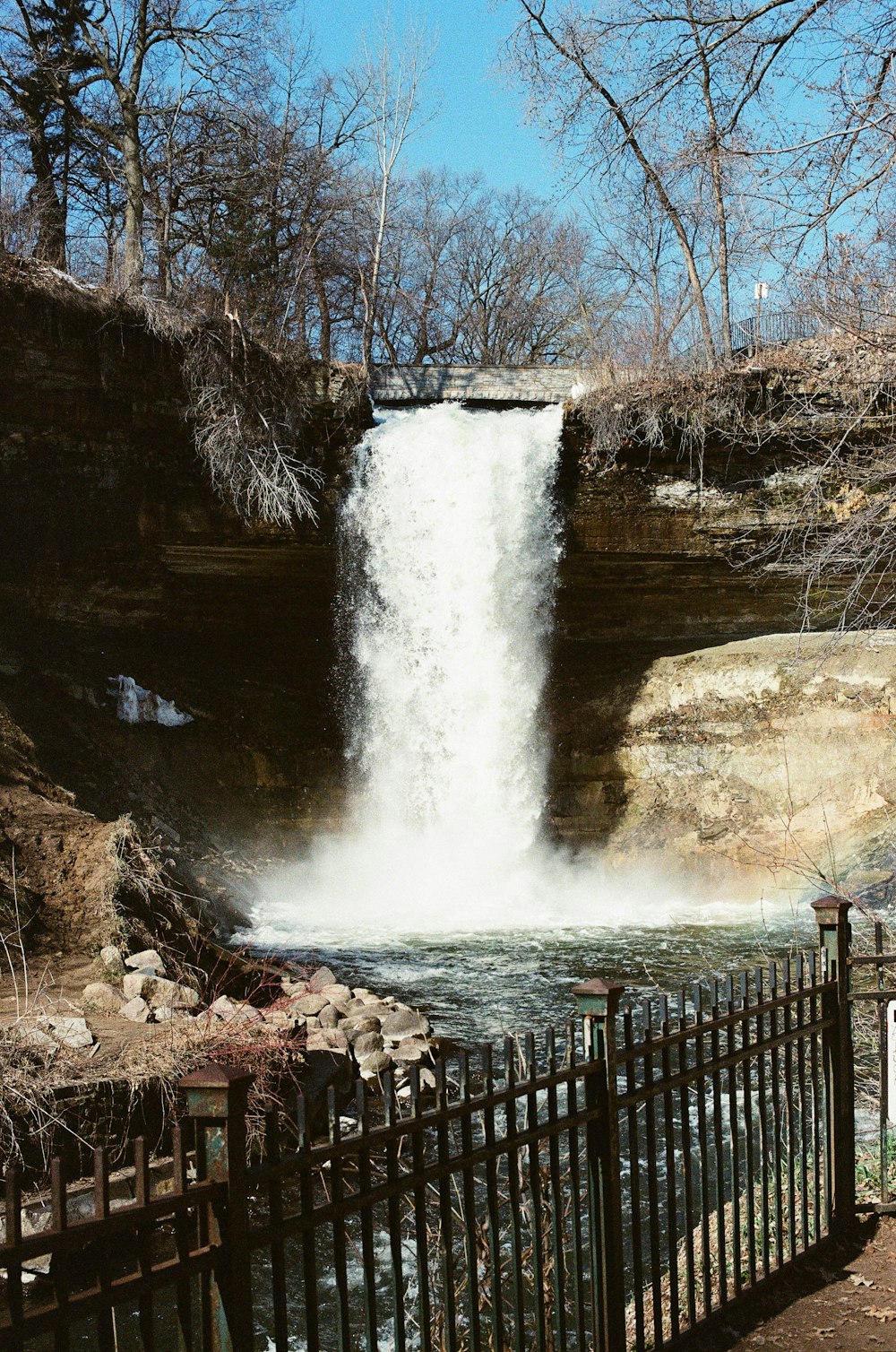 water falls on brown wooden fence