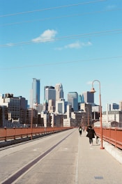people walking on sidewalk near city buildings during daytime
