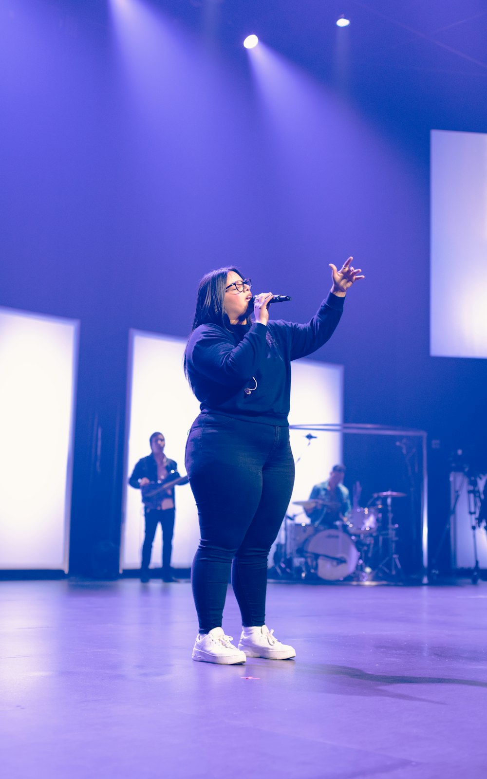 woman in black leather jacket singing on stage