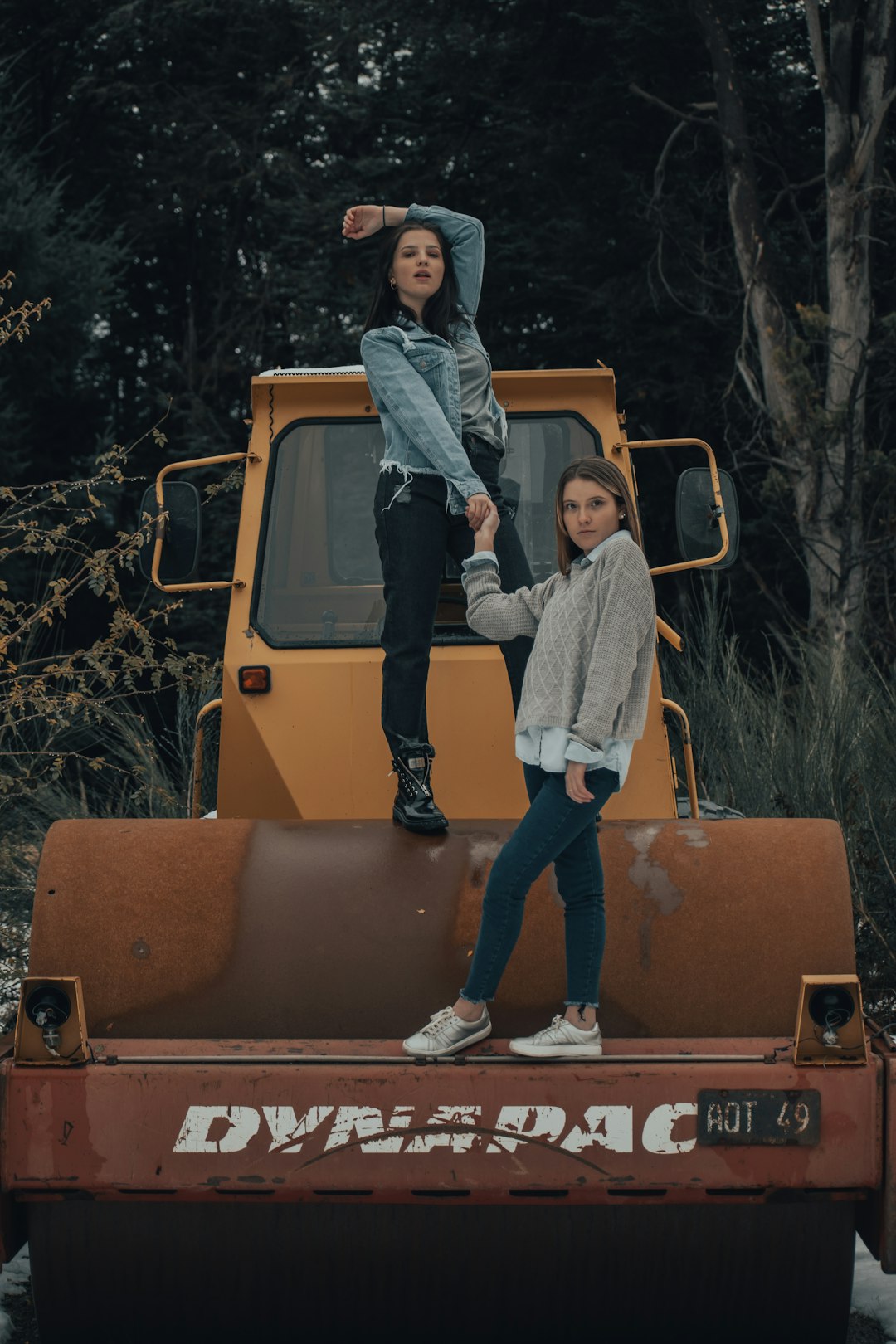 woman in gray jacket and blue denim jeans standing on orange truck