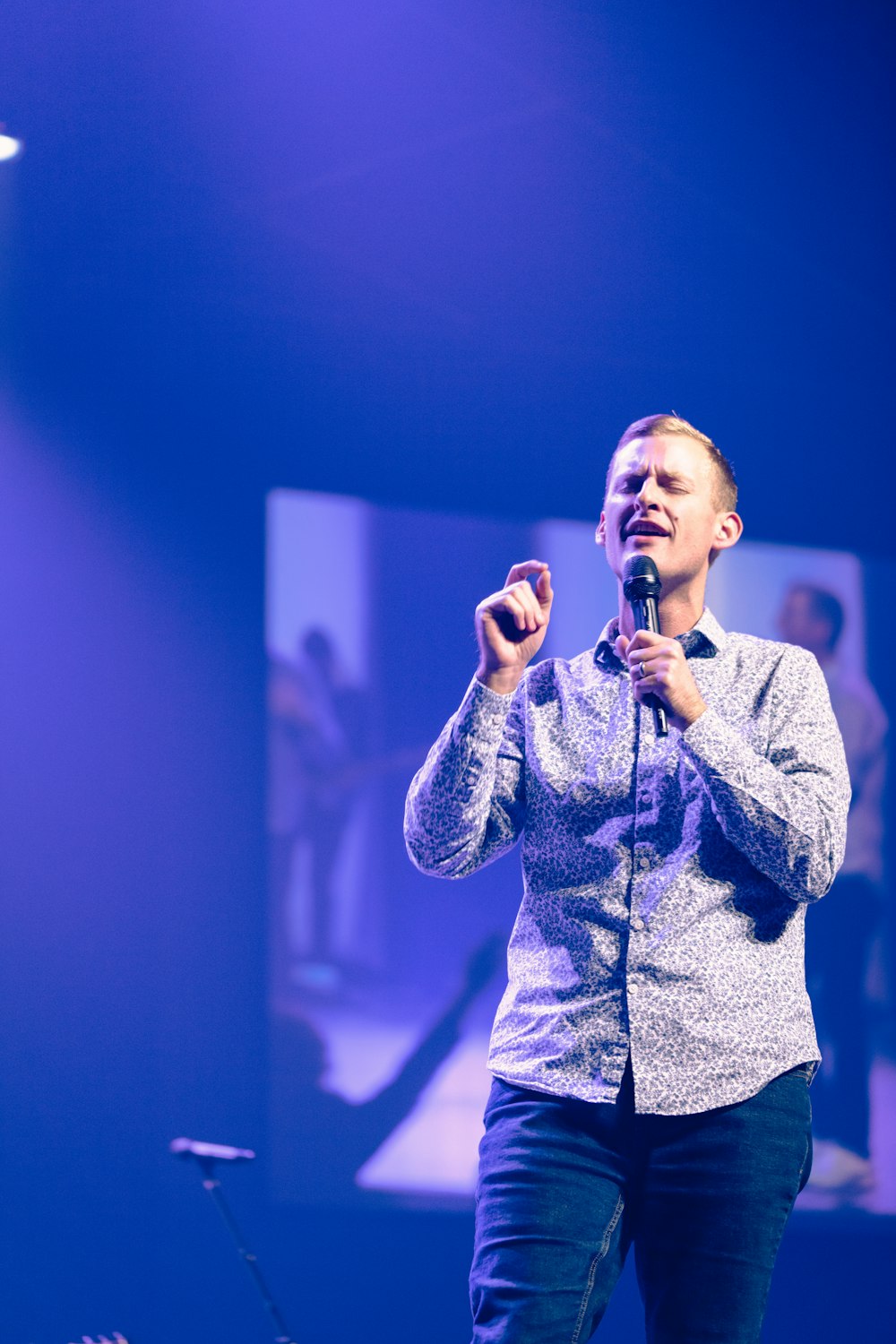 man in gray button up long sleeve shirt holding microphone