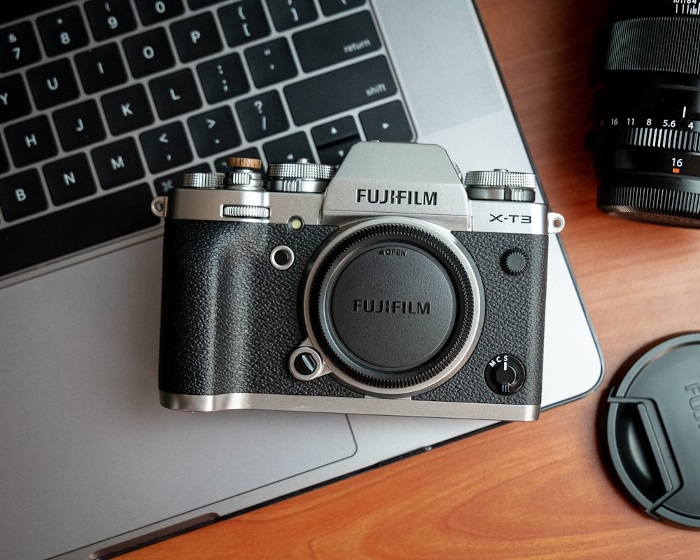 black and silver canon camera on silver laptop computer