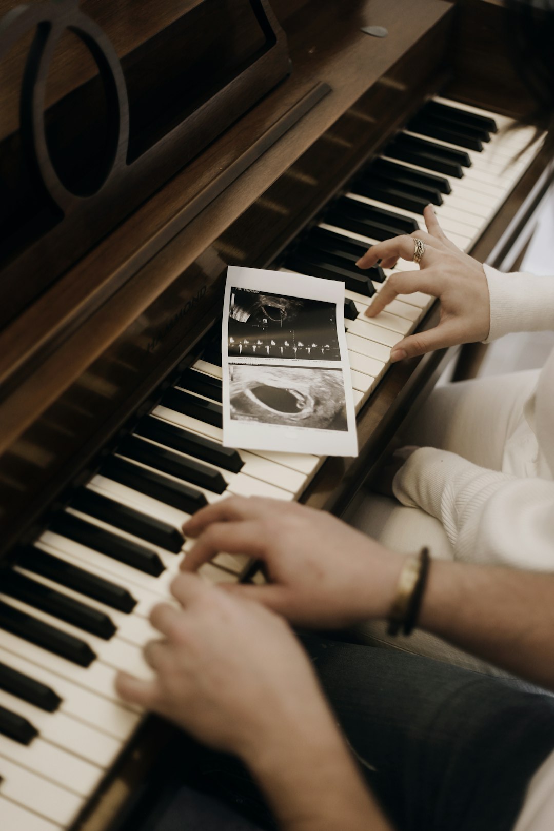 person playing piano in grayscale photography