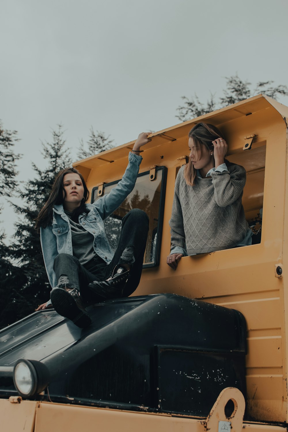 woman in black leather jacket sitting on yellow car