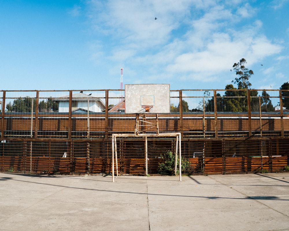 brown wooden fence near white concrete building during daytime