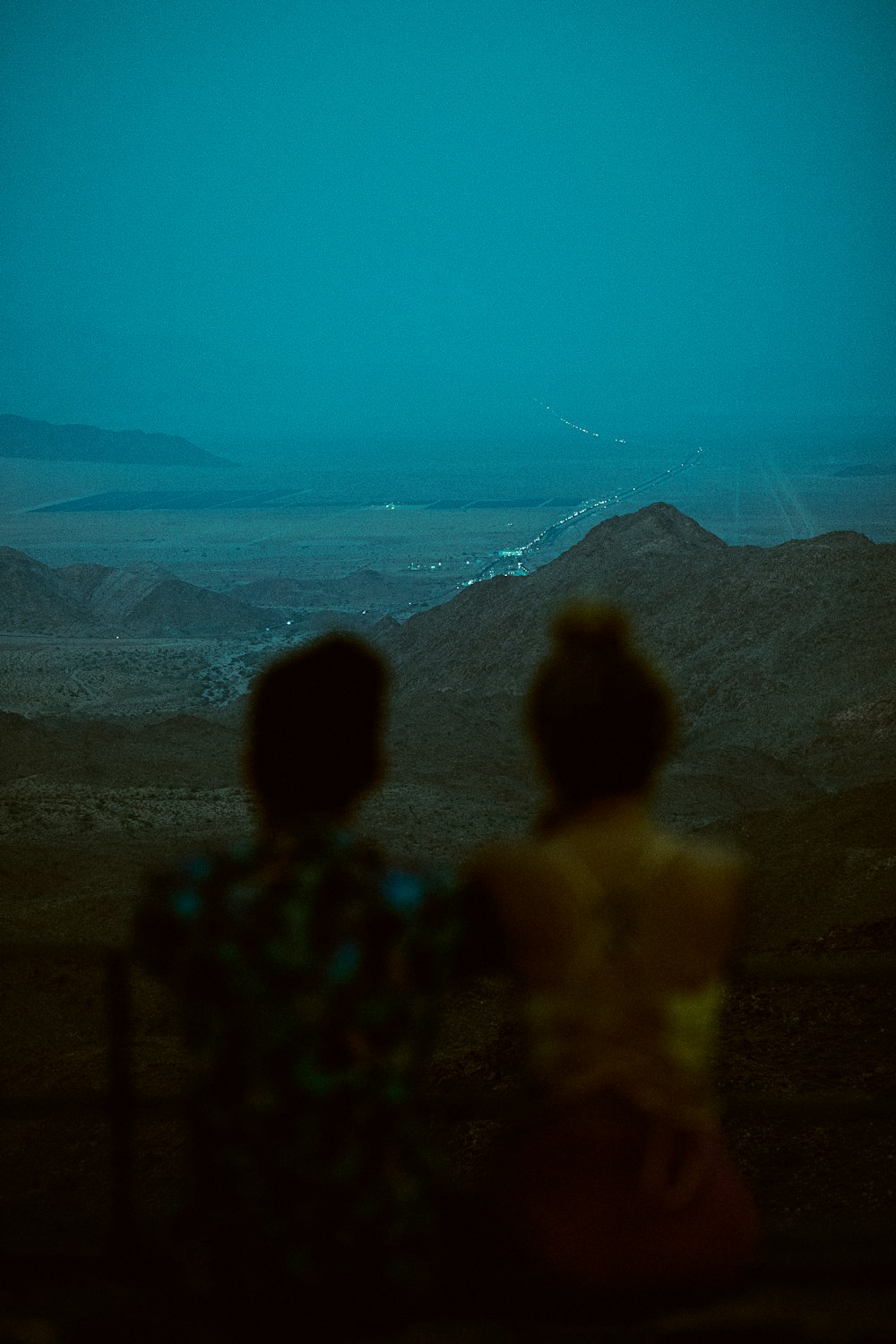 silhouette of 2 people standing on hill during daytime