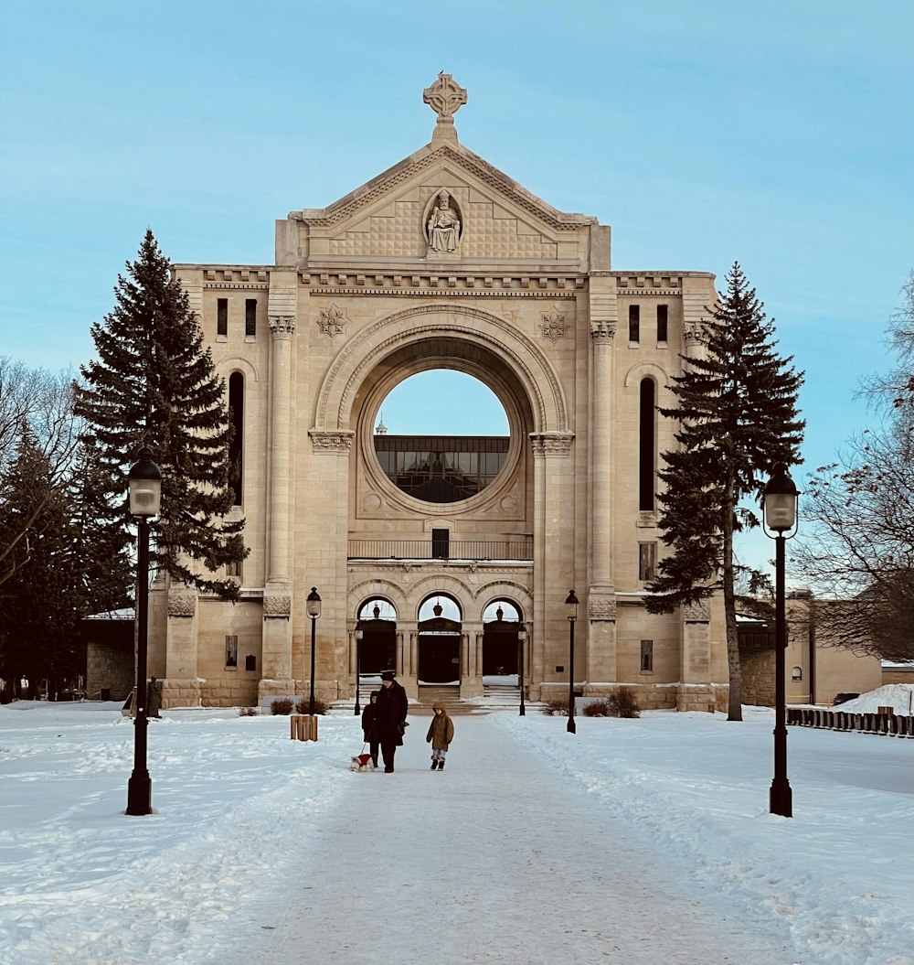 people walking on snow covered pathway near brown concrete building during daytime