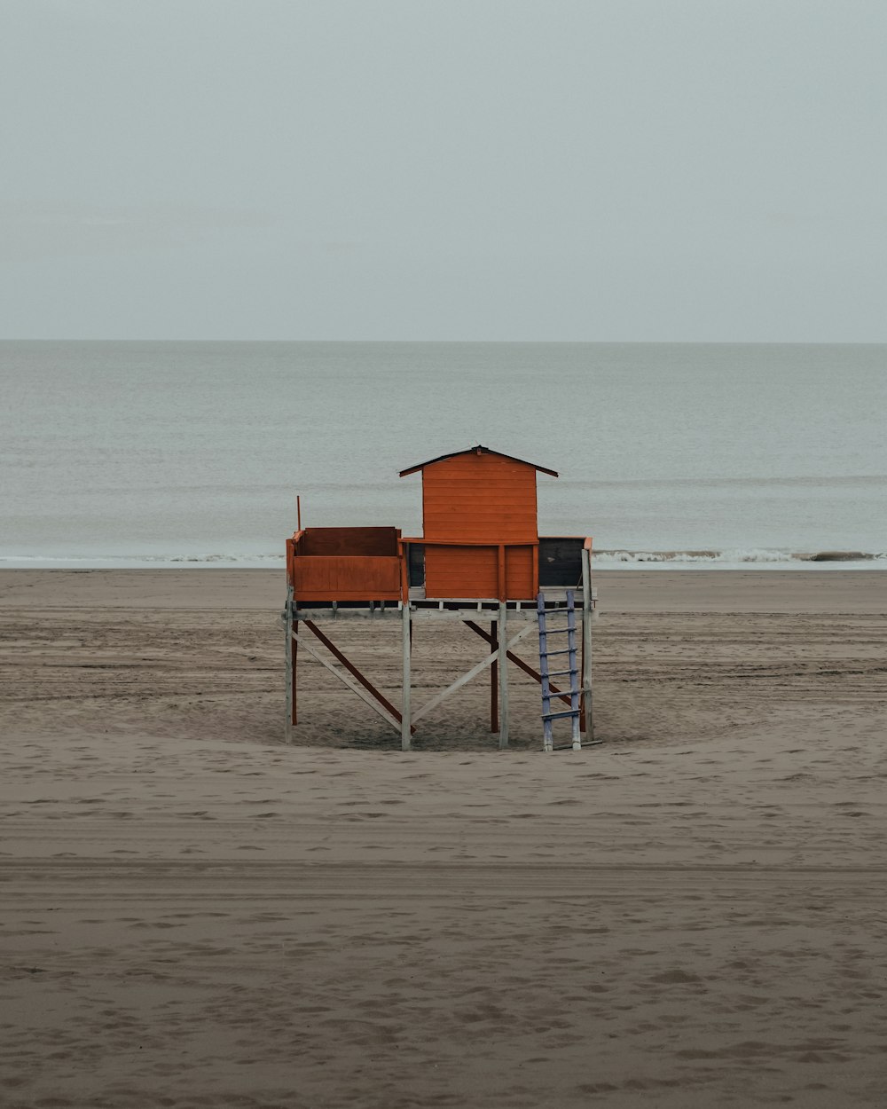 brown wooden lifeguard house on beach shore during daytime