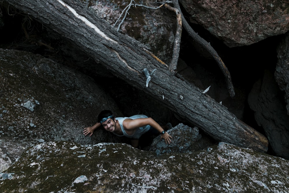 woman in black tank top lying on brown tree trunk