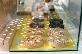 A display of assorted mochi donuts on a wooden board with soft natural lighting.