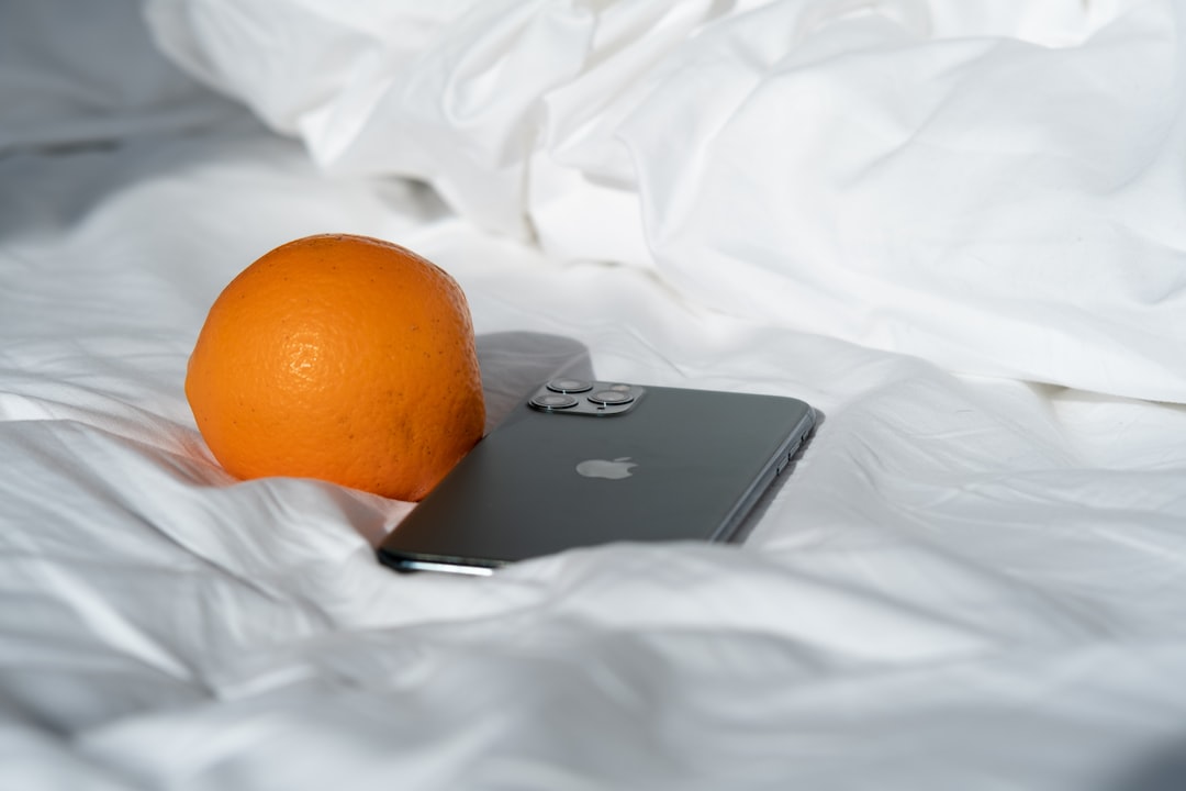 black asus laptop beside orange fruit