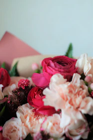 A close-up of a custom event bouquet with rich reds and soft pinks, tied with a simple satin ribbon.