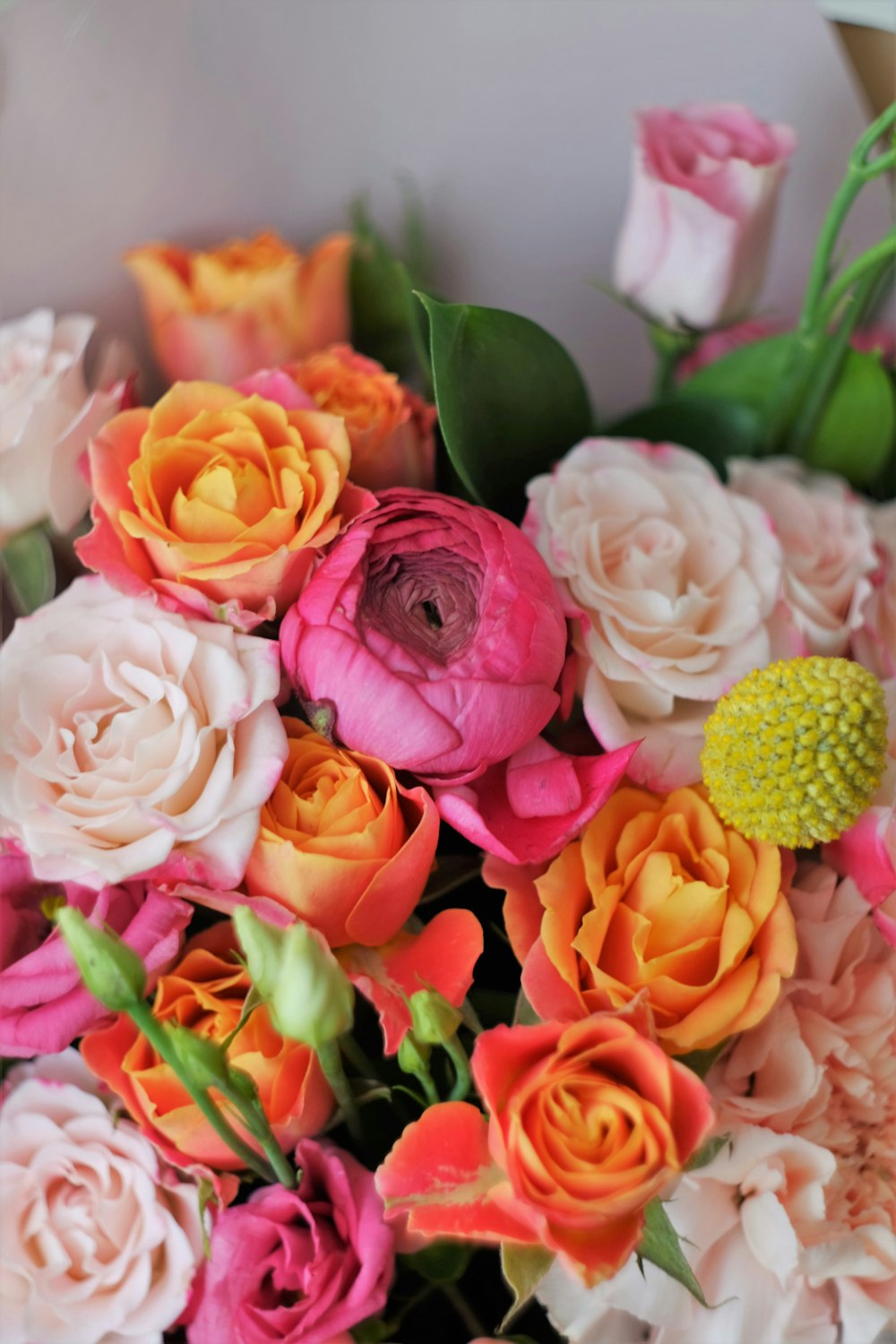 흰색 세라믹 꽃병에 분홍색과 노란색 장미