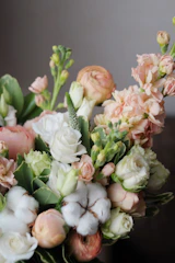 A vibrant bouquet featuring a mix of fresh roses, lilies, and seasonal flowers in soft pastel tones.