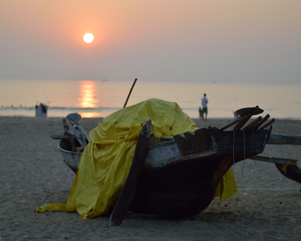 man in green jacket sitting on brown boat on beach during daytime