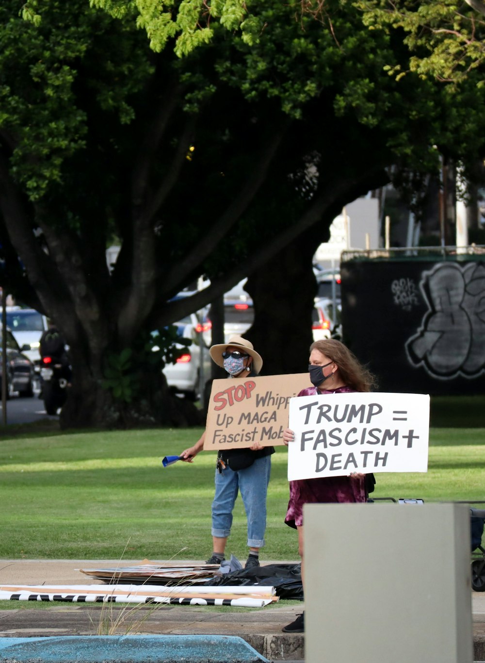 woman in blue denim jeans holding white and black signage