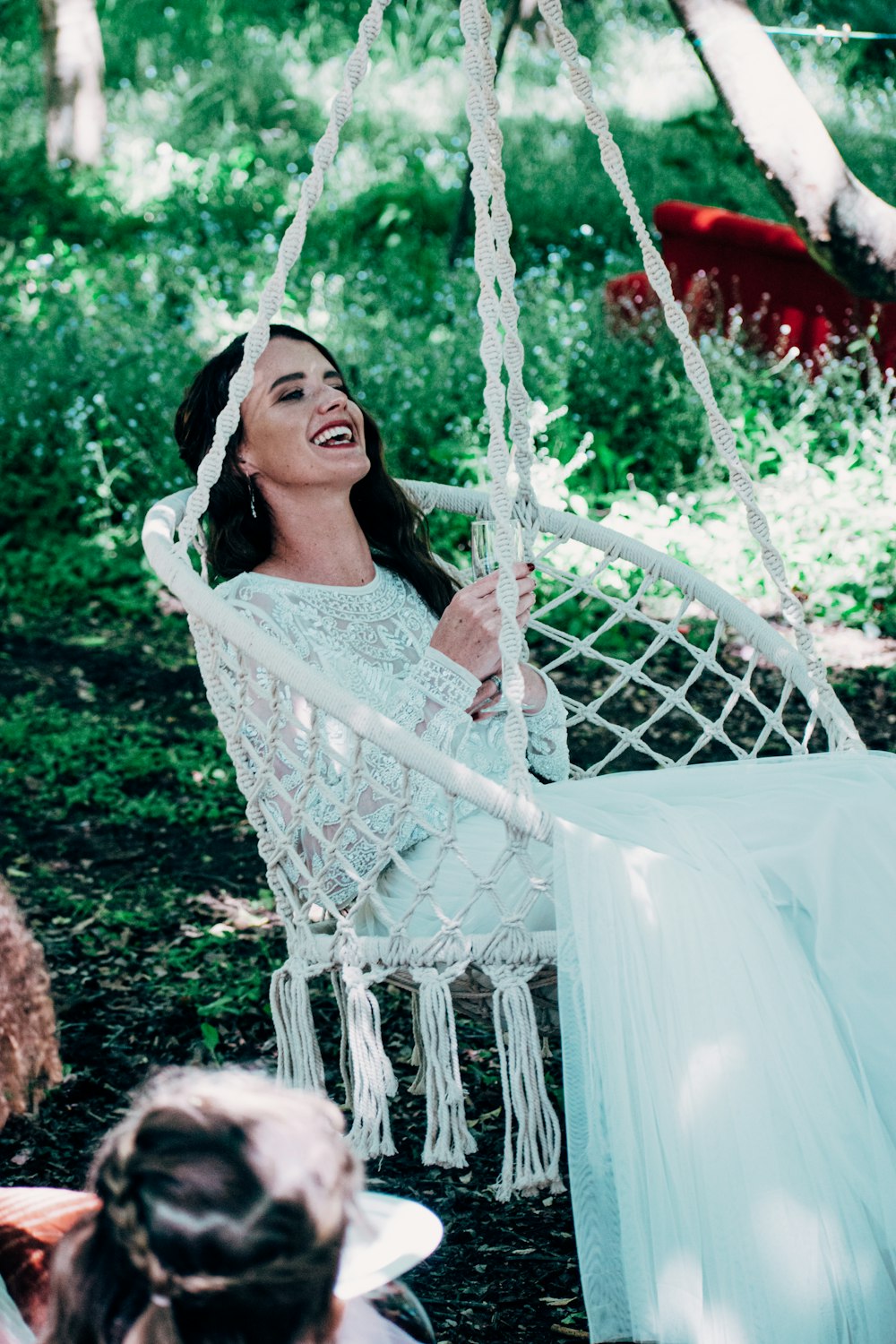 woman in white lace dress sitting on white hammock