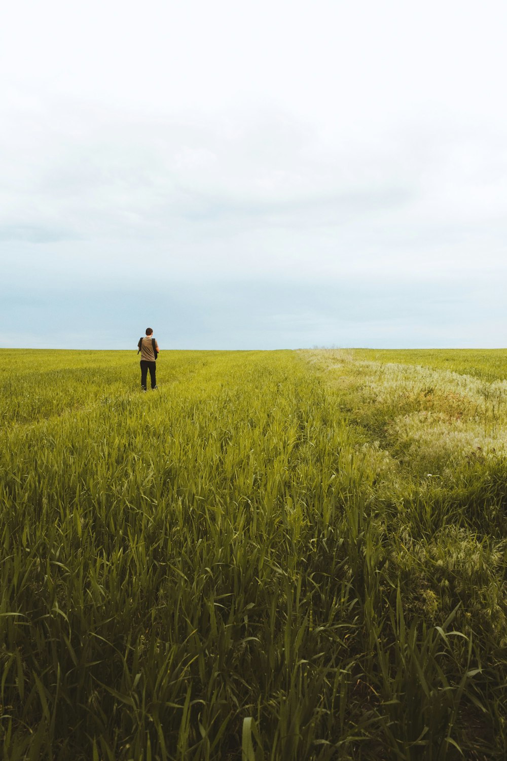 man in black jacket standing on green grass field during daytime