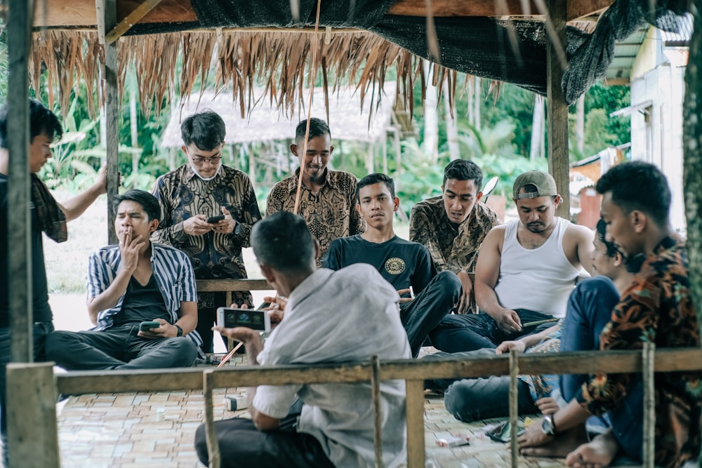 group of people sitting on brown wooden bench