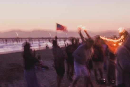 Crowd cheering at a beach sprint race during sunset